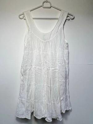 Blus/linne - Ett vitt linne/blus som säkert kan användas som klänning också om man vill det, är ifrån märket Lise Sandahl🌸 - Har dessvärre en liten fläck på baksidan vid nacken, syns inte jätte tydligt men den finns dar... - Längd: 57 cm - One size