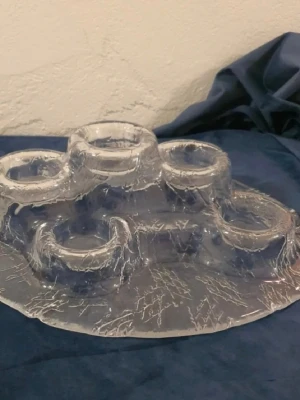 Unik ljushållare i klarglas - Säljer en cool ljushållare i transparent glas med spräckligt mönster. Formen är organisk och har fem upphöjda hållare för värmeljus eller små blockljus. Perfekt som dekoration på bordet för att skapa mysig stämning.