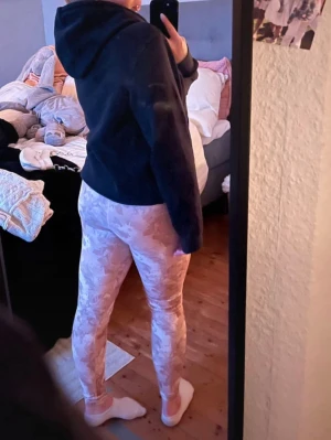 Beigea/rosa camomönstrade leggings - Säljer ett par snygga leggings i beige/rosa med camomönster. De har en tight passform och är stretchiga, perfekta för en avslappnad och trendig look. Materialet känns mjukt och bekvämt mot huden. Passar perfekt till hoodies eller oversized tröjor. Sköna att träna i, inte jätte använda. Säljer även hoodien. Finns bundle rabatt! 