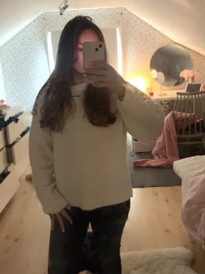 Oversized vit stickad tröja - Mysig oversized vit stickad tröja med rund hals och långa ärmar. Perfekt för lager på lager och enkel att matcha med olika stilar. Tröjan har en avslappnad passform och ribbade muddar vid ärmslut och nederkant.