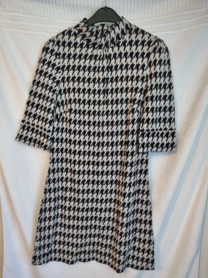 Klänning - Svart och vit mönstrad klänning som är tjockare i materialet. Storlek 38/40. Mått över bysten är 45 cm. Mycket fint skick.