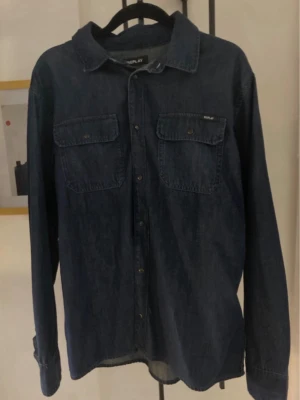 Blå jeansjacka från Replay -   Säljer en helt ny jeansskjorta från Replay i mörkblå/svart nyans med prislappen kvar i strl 16 A=S/M. Nypris 1500 kr. Vid snabb affär kan jag sänka lite 👍 Postar samma dag eller morgonen efter.