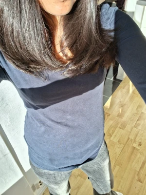 Mörkblå långärmad topp - Hejj jag säljer en enkel, mörkblå, långärmad topp med rund halsringning. Toppen tight och av jätteskönt material.. Perfekt att matcha med jeans eller kjol för en clean look. Tråden har gått upp lite på väster ärmar men det syns inte när den används.