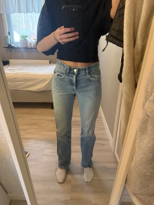 Straight jeans - Väl använda jeans med medel hög midja och raka ben, finns en liten fläck på ena benet som knappt syns (se bild) Längst ned vid benen är det ganska slitet (se bilderna) 