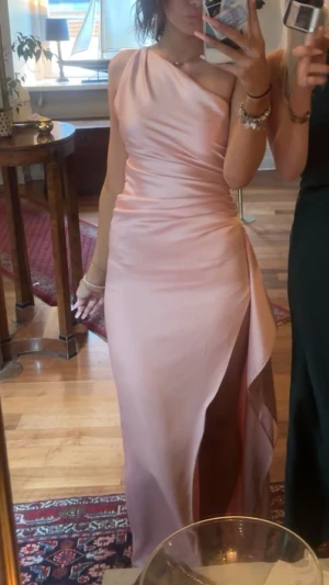 Ljusrosa one shoulder balklänning - Jättefin ljusrosa balklänning, den är uppsydd och jag är 165 och hade ungefär 8 cm klackar och den passar perfekt i längden! Bara använd en gång!