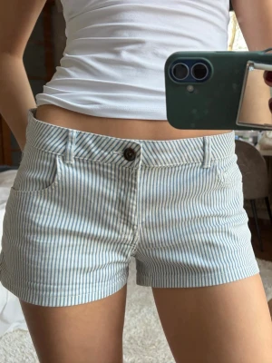 Randiga blåvita shorts med låg midja - Säljer ett par snygga blåvita shorts med ränder. Supersnygga till sommaren!