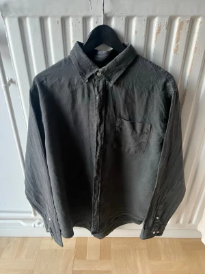 NN07 skjorta - Klassisk svart skjorta med bröstficka och knappar framtill. Skjortan har en avslappnad passform och är tillverkad i mjuk bomull. Perfekt till jeans eller chinos för en clean look.