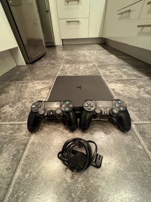 PlayStation 4 Slim med två kontroller - Säljer en PlayStation 4 i mycket bra skick. Allt fungerar som det ska utan problem.  Ingår: 	•	2 kontroller 🎮 	•	2 laddkablar till kontroller 	•	HDMI-kabel 	•	Strömkabel  Perfekt för dig som vill börja spela direkt – allt du behöver ingår.  Konsolen är testad och fungerar felfritt. Redo för snabb affär ✅  💬 Hör av dig vid frågor 