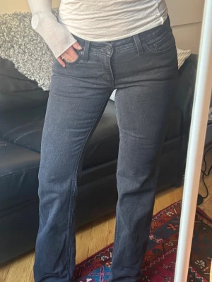 Levis lågmidjade Bootcut - Snygga och unika svarta low waist Bootcut jeans från Levi’s. De har en mörk grå/svart tvätt med stenar på baksidan på fickorna som gör de mer unika! Har bara använt jeansen ca 3 gånger sedan jag köpt de och känner att någon annan kan få bättre användning av de! Iom den sparsamma användningen är de fortfarande i väldigt fint skick.🖤 Storlek 27x32. Ordinariepris 1.125kr