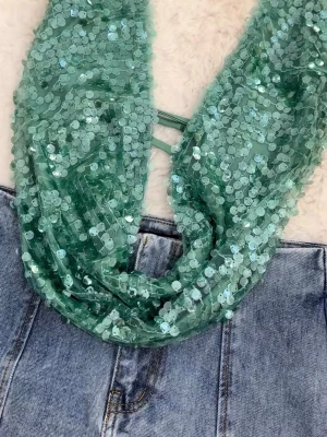 Grön sequin topp med öppen rygg - Trendig grön topp täckt i glittriga paljetter med djup v-ringning och öppen rygg. Toppen är ärmlös och croppad, perfekt för att sticka ut. Snygga band i ryggen ger extra detalj. Passar till jeans eller kjol för en cool look.