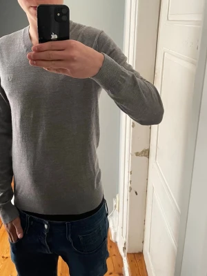 Grå stickad tröja Tiger of Sweden - Säljer en v ringad Tiger of Sweden tröja, mycket bra skick och väldigt snygg över skjortor