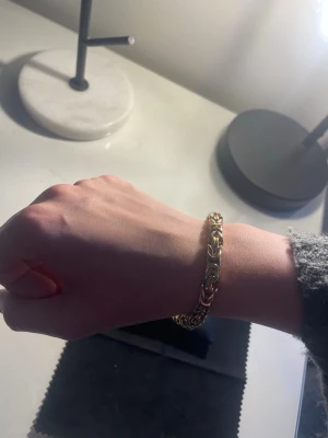 18k guldpläterad Kejsarlänk  - Snyggt armband i 18karat guldpläterad med ett unikt, flätat kedjemönster. Armbandet har en chunky känsla och glänser snyggt i ljuset. Perfekt för dig som vill ha ett statement-smycke som sticker ut och kompletterar din stil. 19cm långt 6x6mm brett