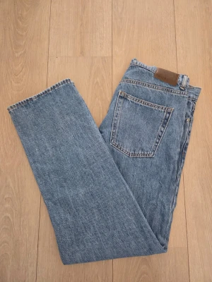 Blå raka jeans från Vaillent - Klassiska blå jeans från Vaillent med rak passform och hög midja. Jeansen har en bakficka och detaljer i kontrastsömmar. Tillverkade i slitstark denim med en snygg vintagekänsla. Perfekta för en avslappnad och tidlös stil.