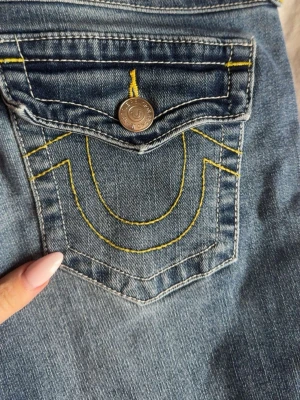 Blå jeans med gula sömmar - Snygga blå jeans med coola gula kontrastsömmar och klassisk femficksdesign. Jeansen har en rak passform och är tillverkade i denim. Perfekta för en avslappnad och trendig look.