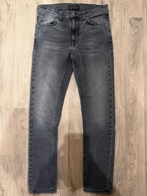Nudie Jeans Lean Dean Grå W30/L30 - Mycket fint skick. Storlek W30/L30. Mått - Midja: 39cm, Ytterbenslängd: 100,5cm, Benöppning: 15cm. Modellen är 185cm & 65kg. Hör av dig vid funderingar!🤝