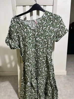Grön blommig klänning  - Blommig grön klänning, knappt använd! Storlek L men passar som en M