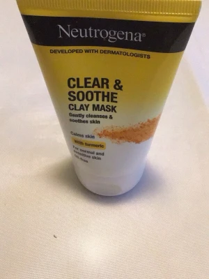 Neutrogena Clear & Soothe Lermask - Neutrogena Clear & Soothe Clay Mask är en ansiktsmask med gurkmeja som lugnar och rengör huden skonsamt. Passar normal och känslig hud, är oljefri och kommer i en praktisk tub med gul och vit design.