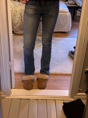 Blå slim fit jeans med låg midja - Snygga blå slim fit jeans från vero moda med låg midja och klassiska fem fickor. Jeansen har en lätt tvättad look och raka ben. Perfekta för dig som gillar en enkel och stilren jeansstil. Strl 25/32