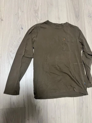 Olivgrön långärmad tröja från Fjällräven  - Olivgrön långärmad tröja från Fjällräven, inga problem med den. Tvättas innan leverans 