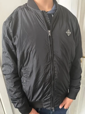 J.Lindeberg Bomberjacket  - Hej! Säljer nu denna väldigt snygga bomberjacket från J.Lindeberg. Jackan är väldigt perfekt nu till våren som börjar närma sig och är i fint skick! Storleken är L och ny pris är 3499 kr och säljer den endast för: 999 kr!