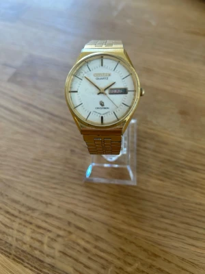 1977 Citizen Cryston Day Date 34mm - Säljer en mycket unik och ovanlig vintage klocka från japanska Citizen. Klockan är i mycket gott skick för sin ålder enl. bilder med framförallt smuts och inte skador. Urverket fungerar bra, originalarmband i rostfritt stål, guldpläterad, dag och datumvisare, vattentät osv. Behöver bara nytt batteri. Modell nr: 8550-921871. Se sista bilden för mer info.  Begagnat pris: < 4000 SEK Mitt pris: 989 SEK  Skickas alltid snabbt och spårbart. Hör av dig vid frågor & se gärna mina andra annonser.
