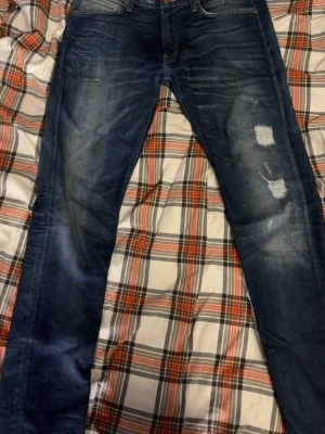 Lee Jeans - Säljer dessa fina jeans från Lee! Jeansen har sjukt snygga slitningar samt ett eget designat mönster. Unika jeans som inte hittas nån annanstans! Inga defekter förutom dom egengjorda😅sitter som 31/34, hör av er om ni vill ha mått eller har andra frågor! Pris 299kr!