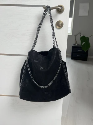Väska - Stilig handväska med kedjor och fejk-läder. Endast använd ett fåtal gånger, vet inte märket då jag fått den i present 🩷
