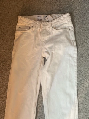 Vita raka jeans från 157 - Snygga vita jeans från 157 med rak passform och klassisk femficksdesign. Perfekta för dig som gillar stilrena och enkla basplagg. Materialet är bomull med lite stretch för extra komfort.