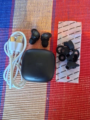 Svarta Urbanista in-ear hörlurar - Säljer ett par svarta Urbanista trådlösa in-ear hörlurar med laddningsetui, USB-laddkabel och flera extra silikontoppar. Hörlurarna har en rundad, kompakt design och är tillverkade i plast med mjuka silikonproppar för skön passform. Kan postas/ skickas 24/3