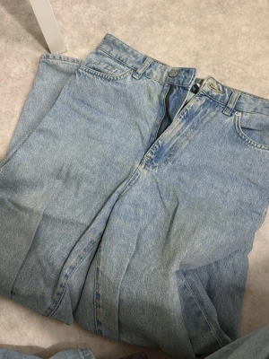 Jeans  - Ett par fina hela blåa jeans. Storlek 34/xs. Väl använda men inga fläckar eller skavanker. Jag har sytt in ett extra ”snöre” så att man kan knyta dom tajtare i midjan om man vill. Kan såklart tas bort om det önskar! Dom är high waist och loose i modellen, alltså inte tajta. Jag skulle tycka att dom sitter lite mer format över rumpan sen är dom ”raka”  