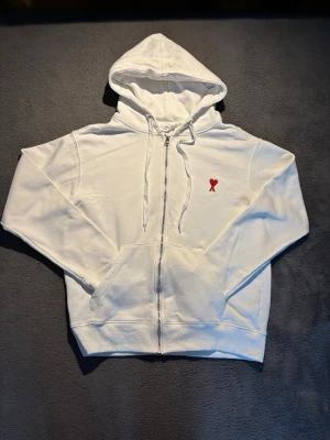 Vit zip hoodie från Ami Paris - Vit hoodie med dragkedja från Ami Paris. Är i mycket bra skick har inte använts mer än 2 gånger, storlek S