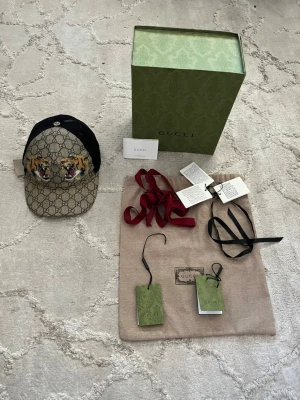 Gucci tiger keps - Säljer en mycket fin och unik gucci keps I storlek S som motsvarar 57cm. En pytteliten defekt OBS se bild 2 där framme. Allt på bilden medföljer!
