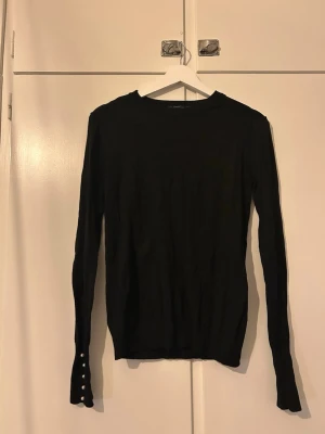 Finstickad med pärldetalj - Långärmad finstickad tröja från Zara i storlek M. På ärmsluten finns pärlor som en fin detalj. Mjukt och stretchigt tyg och som är figurnära utan att sitta åt.
