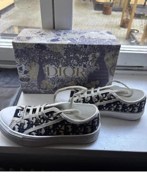 Dior Oblique låga sneakers - Snygga låga sneakers med klassiskt blått och vitt Oblique-mönster. Perfekta för dig som vill ha en lyxig och trendig look. Använda 1 gång. Har tyvärr inget bevis på om de är äkta därför säljer jag de billigt! Hör av er vid frågor eller fler bilder! 🫰🏼💕💕