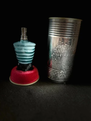 Jean Paul Gaultier Le Male parfym - Köpt för 970kr. Klassisk herrparfym från Jean Paul Gaultier, Le Male. Flaskan har en unik design i form av en manlig torso i blått och turkost glas med ränder. Kommer med en metallisk silverfärgad burk som förpackning. Perfekt för dig som gillar ikoniska dofter. Har används några gånger.