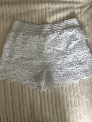 Vita spetsiga shorts med volang - Superfina vita shorts med spets och volangdetaljer. . Perfekta för sommardagar och lätta att matcha med en enkel topp.💕💕