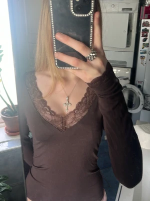 Brun långärmad topp med spets - Mörkbrun långärmad topp med v-ringning. aldrig använd. storlek xs. passar s och xxs också. 