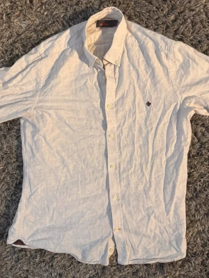 Beige  linneskjorta från Morris🙌🤩 - Snygg beige skjorta från Morris i linne med klassisk krage och knappar framtill. Skjortan har lång ärm och en liten broderad logga på bröstet. Perfekt för en stilren och avslappnad look.🙌🤩