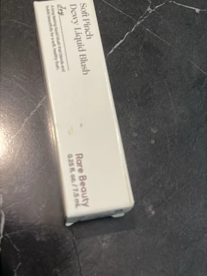 Rare Beauty Soft Pinch Dewy Liquid Blush - Rare Beauty Soft Pinch Dewy Liquid Blush i en smidig förpackning på 7,5 ml. Flytande rouge som ger en fräsch och daggig finish. Perfekt för att skapa en naturlig glow och enkel att applicera med applikator. Kommer i en stilren, ljus förpackning.