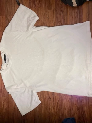 Vit basic t-shirt från 157 - Enkel och stilren vit t-shirt från 157. T-shirten har rund halsringning och korta ärmar, perfekt för en clean och avslappnad look. Tillverkad i mjuk bomull som känns skön mot huden.