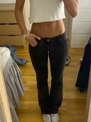 Svarta bootcut jeans Lee  - Säljer ett par svarta lågmidjade bootcut jeans ifrån lee i storlek 25 waist och längd 31, skulle säga att de är som 34 i storlek 
