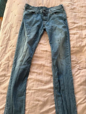 Ljusblå skinny jeans från Dr Denim - Snygga ljusblå skinny jeans från Dr Denim med klassisk femficksdesign och normal midja. Jeansen har en smal passform och är tillverkade i stretchigt denimtyg för extra komfort. Perfekta för en avslappnad och trendig look.