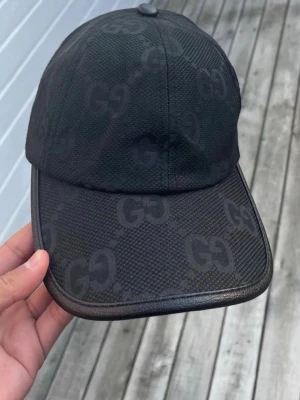 Svart Gucci keps - Svart Gucci keps, väldigt sparsamt använd (använd under vinter max 5 gånger annars har den bara legat i ett skåp som prydnad) öppen till pris förslag. 