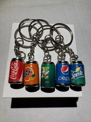 Nyckelringar med läskburksmotiv - Fem nyckelringar med miniatyrburkar av Coca-Cola, Fanta, 7up, Pepsi och Sprite. Nya!