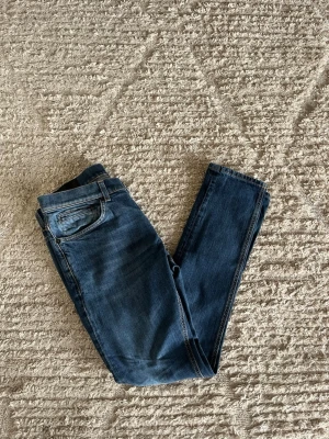 Dondup George jeans  - Säljer nu dessa fina blåa Dondup George jeans i nyaste års modellen. Inga skador eller defekter 9/10. Midja:42cm. Lår: 26cm. Ytterlängd:102cm. Innerlängd 80cm. 