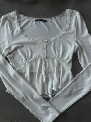 Vit långärmad topp med spetsdetaljer - Lång ärmad crop-top från Gina. Aldrig använd så den är i nyskick. Storlek XS