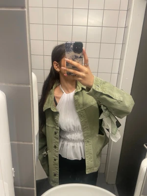 Ljusgrön jeansjacka med klassisk passform - Snygg ljusgrön jeansjacka med klassisk krage och knäppning framtill. Jackan har raka ärmar, bröstfickor med lock och en avslappnad passform. Perfekt för att lyfta din outfit med en cool touch.