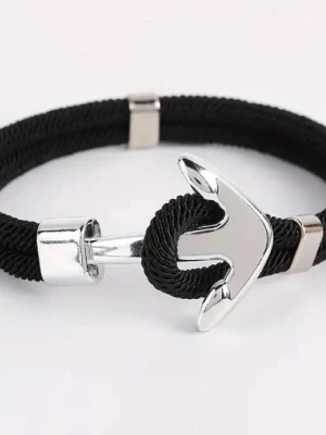 Svart armband med ankare i silver - Stilrent armband med svart flätat rep och ett coolt ankare i silverfärgad metall som lås. Perfekt accessoar för en modern look med nautisk touch. Passar både till vardagsoutfit och när du vill sticka ut lite extra.
