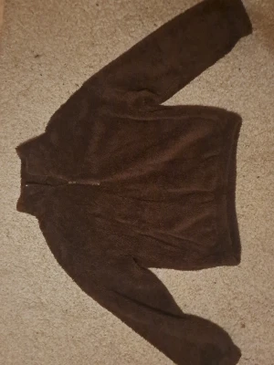 Brun teddytröja med dragkedja - Mysig o söt fluffig brun teddytröja il med hög krage och lite dragkedja framtill. 