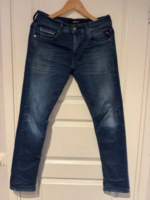 Mörkblå jeans från Replay - Snygga mörkblå jeans från Replay med klassisk femficksmodell och raka ben. Jeansen har en lätt tvättad look med subtila slitningar och kontrastsömmar. Perfekta för en avslappnad och trendig stil. Modellen är Replay Grover Hyperflex.